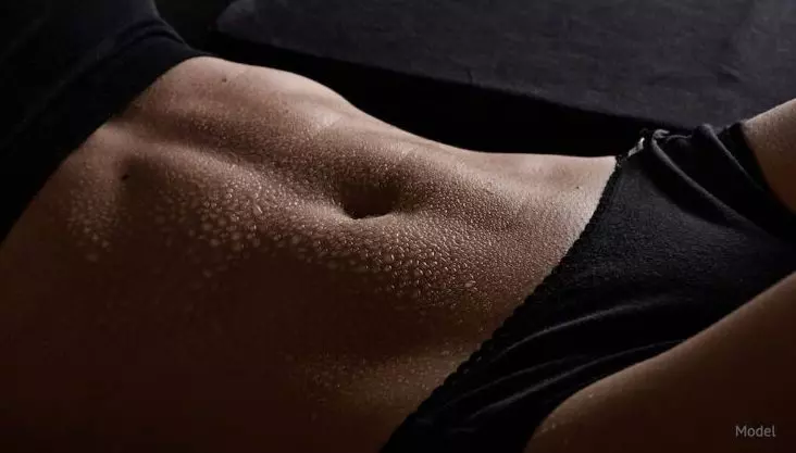 Flat stomach that tummy tuck can achieve with dark lighting