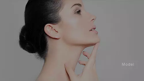 profile headshot of woman caressing her sculpted neck and chin