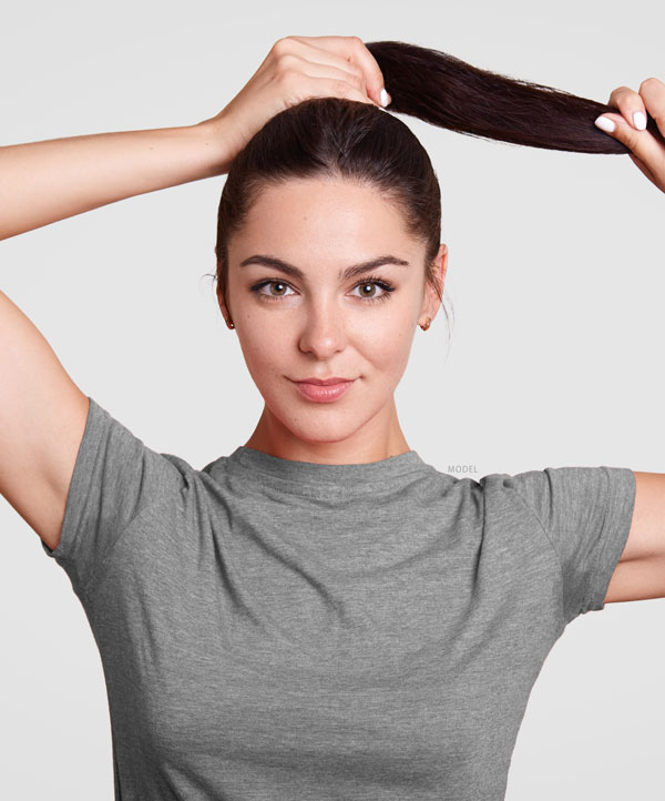 Headshot of woman holding back her ponytail