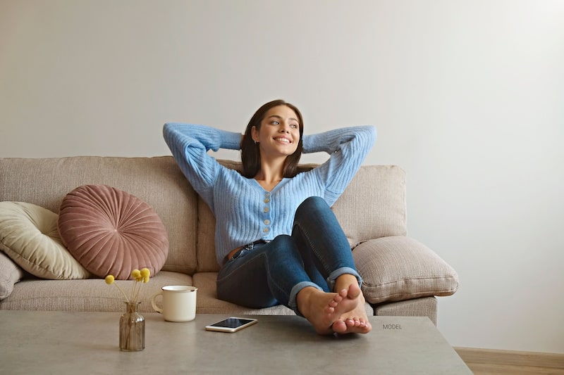 Woman lounging on a sofa at home.