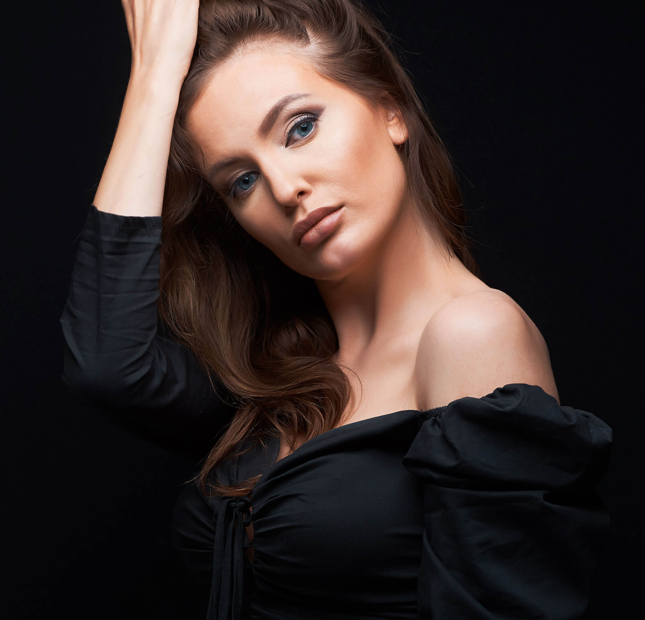Woman in a black dress against a black background