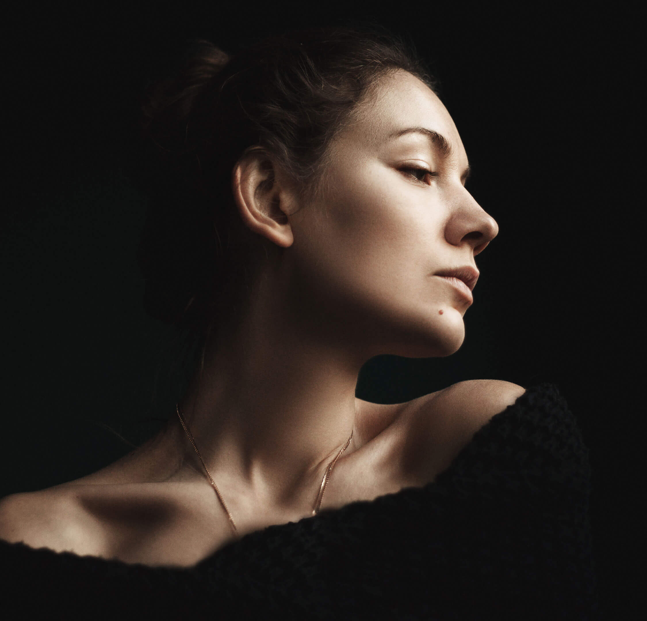 Dark haired woman against black background