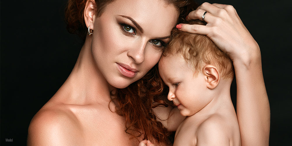Female with a baby on a black background