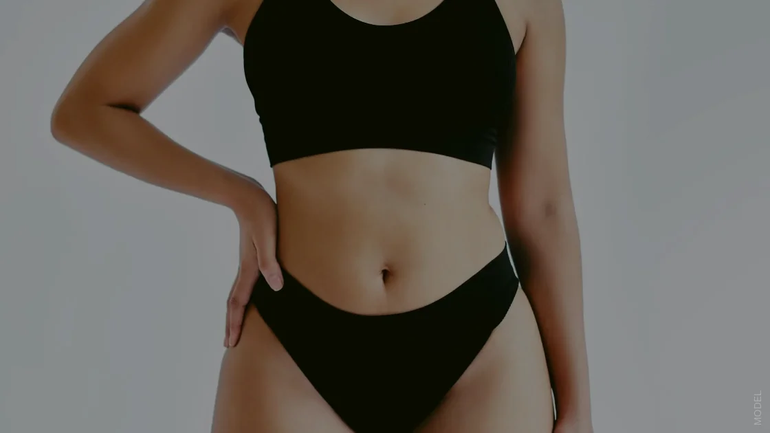 woman with one hand on her hip wearing a black top and underwear